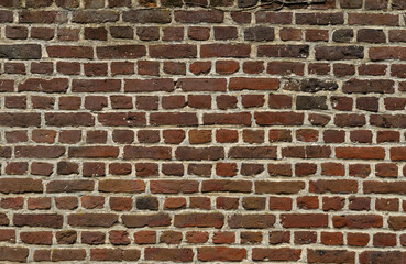Dark brick wall in red tones in a ruined house in the Belgian city of Ghent.