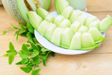 Fresh green melon on wood plate