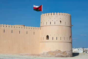 Tower of Sunaysilah fort in Sur featuring raised Omani flag