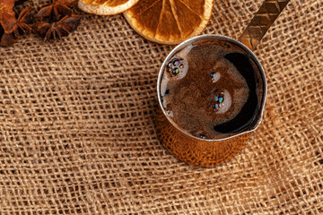 Shiny copper turk with brewed coffee on brown wooden table