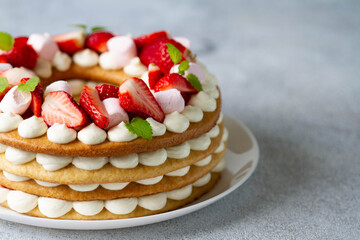 Cake with whipped cream, strawberries and marshmallows.