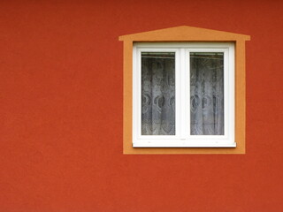 Window  with curtains and frame on orange wall