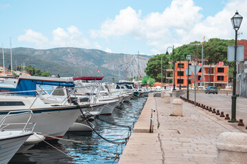 Fototapeta na wymiar Walking promenade of Starigrad, Hvar, Old boats docked in the harbour, straight line leading through the city town center