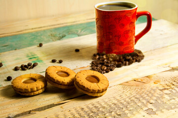 Red mug of coffee cookies on a wooden table.
