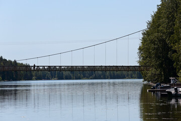 A long cable bridge over a sunny river