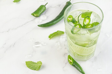 cocktail with cucumber, chili and ice and place for text.