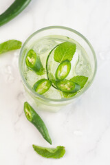 cocktail with cucumber, chili and ice top view.