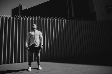 Black and white photo. Portrait sportsman in the stripes wall. Contrast theatre art. Men emotion.