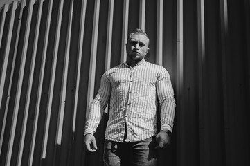 Black and white photo. Portrait sportsman in the stripes wall. Contrast theatre art. Men emotion.