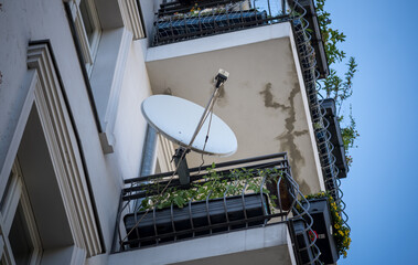 Satellite dish of a parabolic antenna on a balcony, view from below