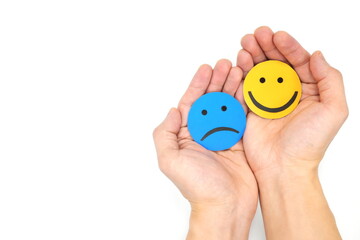 Friendship, sympathy and share happiness concept. Hands holding sad and happy faces hugging each other. Suicide prevention day.