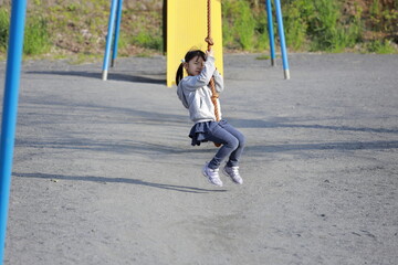 ターザンロープで遊ぶ幼児(5歳児)