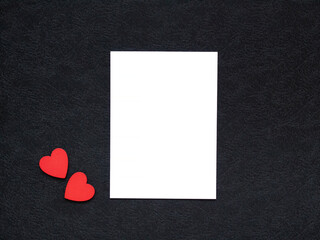 blank white paper and red hearts on black background. love background. Valentine's day concept 