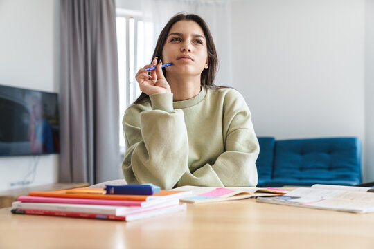Photo of concentrated student woman thinking while doing homework