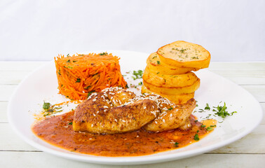 Fried lemon chicken with fried potatos and carrot salad front view