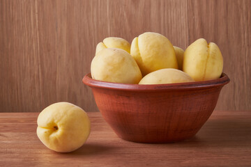 fresh apricots in a Cup on a wooden table