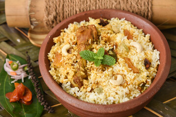 Spicy and delicious chicken biryani in traditional clay pot. Malabar biryani or Hydrabadi chicken biryani, Dum Biriyani, Chicken pulao basmati rice, herbs, raitha for Ramadan Kareem, Eid-Ul-Adha