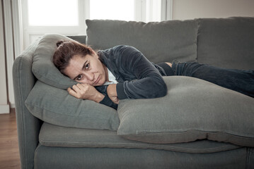 Young sad woman suffering from depression feeling lonely and hopeless isolated at home