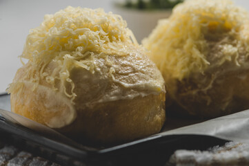 Buttery and Cheesy Ensaymada ( Bun topped with Butter Sugar and Cheese) - Filipino Bread Snack- Side View