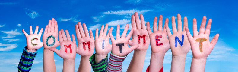 Children Hands Building Colorful Word Commitment. Blue Sky As Background