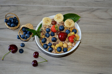 Cereals with blueberries, bananas, strawberries, and cherry.