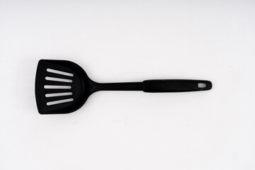 spade of frying pan made from plastic on white background selective focus, kitchen flipper