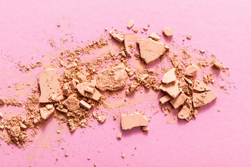 top view of beige and cracked face powder on pink