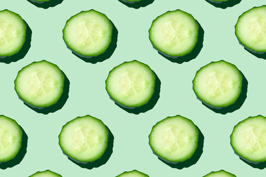 Regular Seamless Pattern Of Cucumber Slices On A  Pastel Mint Background.Photo Collage,hard Light, Shadow,pop Art Design. Food Blog, Vegetable Background. Printing On Fabric, Wrapping Paper.Top View.