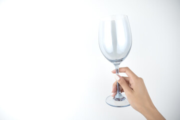 image of woman's hands holding empty glass of wine on isolated white background