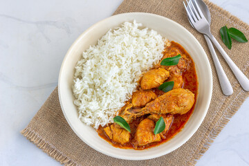 Chicken Kori Gassi, Mangalorean Chicken Curry with Rice Garnished with Curry leaves in a Bowl Directly Above Horizontal Photo
