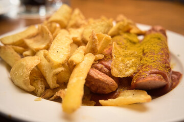 Traditional Eastern German meat dish - currywurst (curry sausages) served with French fries and mustard