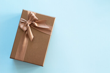a gold color gift box on blue background with space fot text