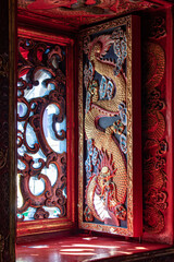 Carved shutters in an oriental temple. Richly decorated shutters with dragon theme, Chinese Buddhist monastery.