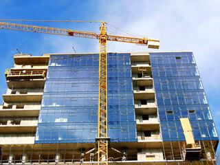 Building under construction. Construction site. Crane near building.