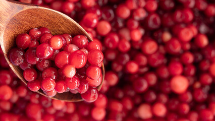 Cranberry placed in a wooden spoon and placed on a wooden floor,  Red sour fruit  There are many health benefits.