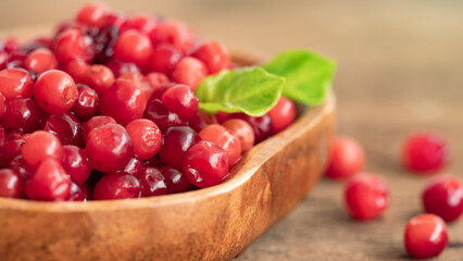 Cranberry placed in a wooden cup and placed on a wooden floor,  Red sour fruit  There are many health benefits.