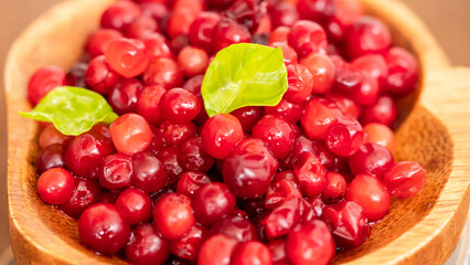 Cranberry placed in a wooden cup and placed on a wooden floor,  Red sour fruit  There are many health benefits.