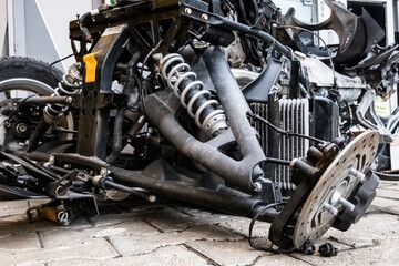 Vehicle, tricycle, after an accident. A burned motorcycle near the workshop. Mechanism metal covered in ashes. Various motorcycle mechanisms are visible. Gears, springs, tanks, skeleton, traction.