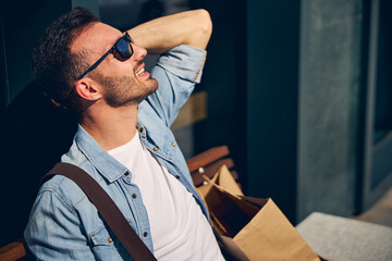 Positive delighted male sunbathing on the street