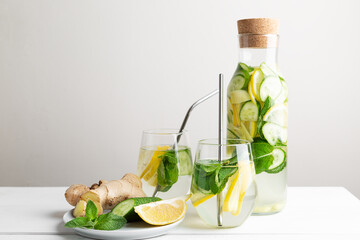 Rejuvenating drink, cocktail, water with lemon, ginger, mint, cucumber on a white background.