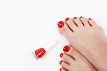 Female legs and red nail polish on a white background.