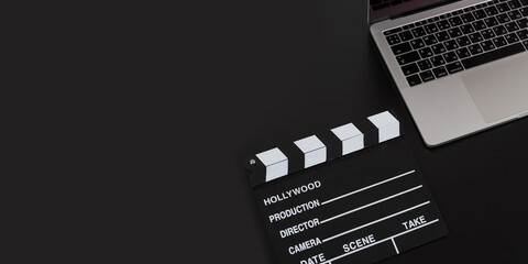 Camera with laptop and clapper movie isolated on black background