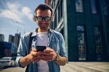 Joyful young man reading income message on telephone