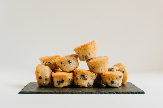 Chocolate chips little muffins in a dark slate board plate isolated on white. Muffin, sweet and food concept.
