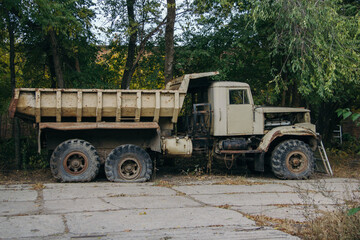 Obraz premium Old rusty truck at abandoned overgrown industrial area