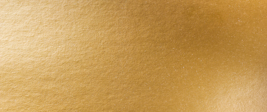 Gold texture background. Golden shiny foil paper panorama. Soft shine gradient reflection