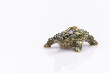 close-up of a green plastic tortoise isolated on a white background