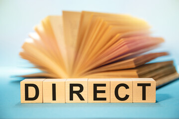 Open book and Wooden cubes with the abbreviation DIRECT