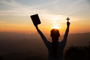 Hands of a Christian Women holding a bible and cross while praying to God, Religious beliefs, Copy...