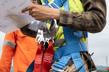 Construction worker wearing safety harness at construction site